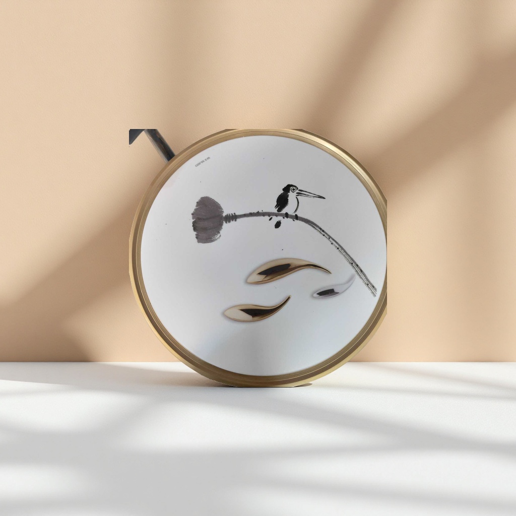 A white round tray with ink-wash birds perching on the branches is decorated with gold and silver metal spoons