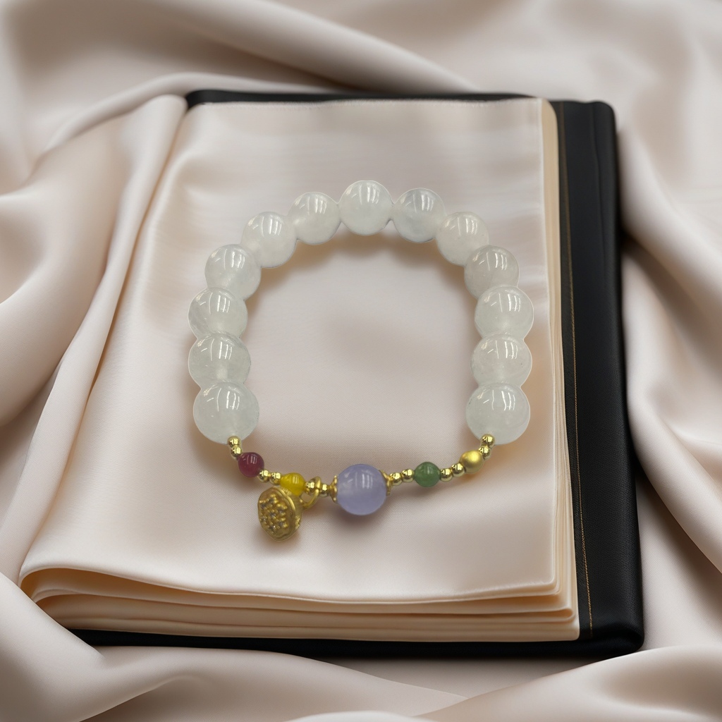 A white beaded bracelet decorated with small purple, green, red and gold beads and a gold pendant