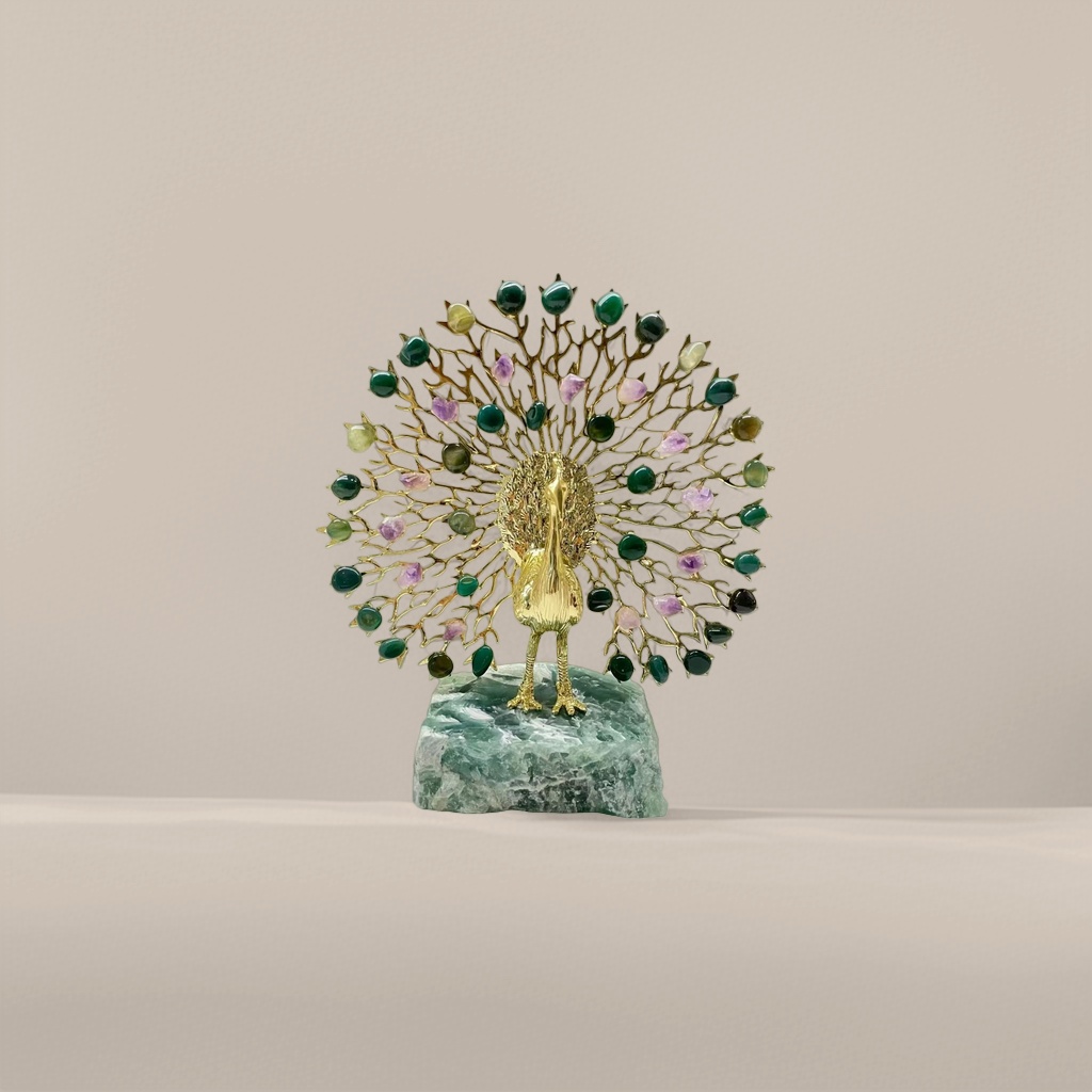 A golden peacock figurine set with emeralds and amethysts stands on a green jade base