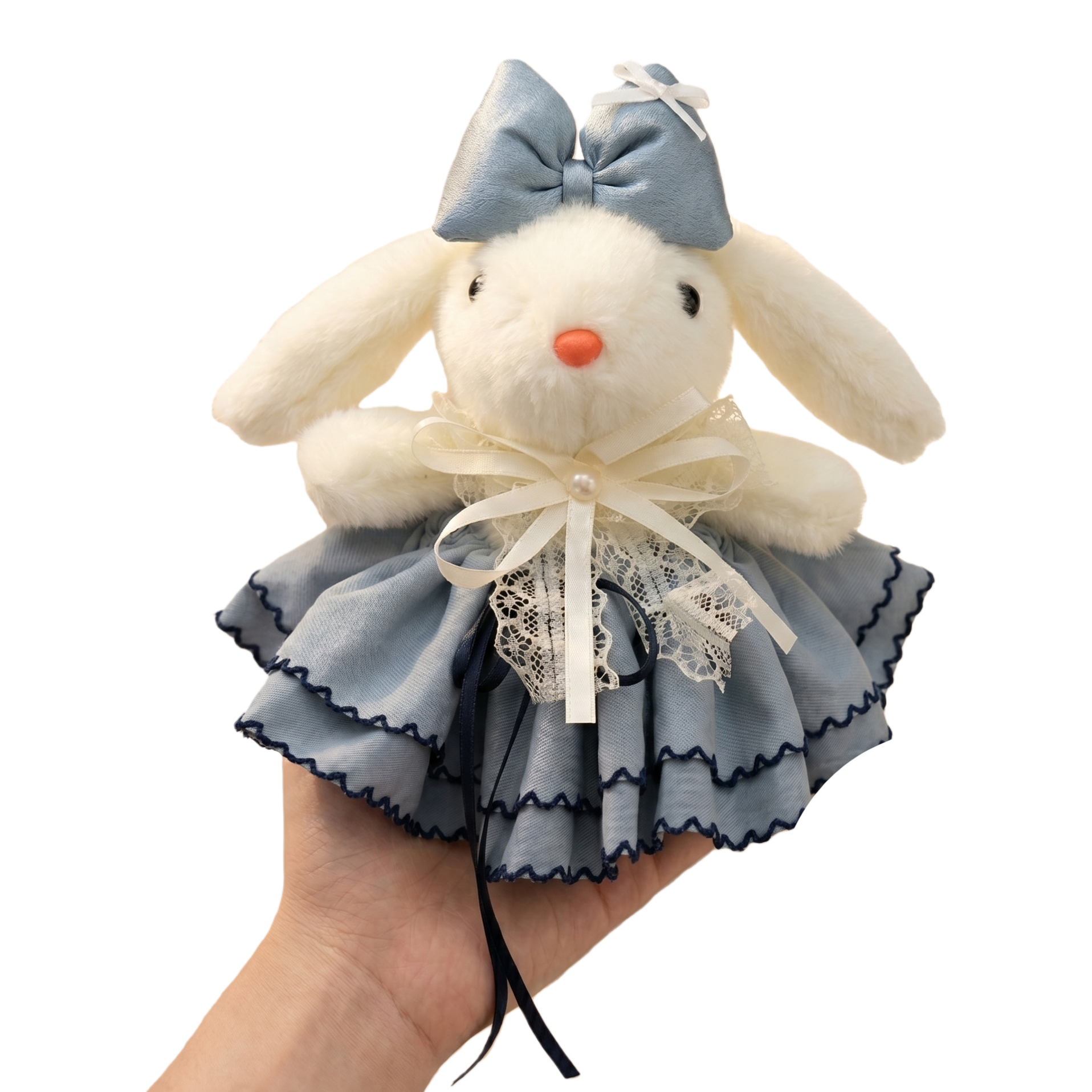 A white plush rabbit doll is wearing a light blue bow on its head and a light blue ruffled skirt decorated with lace and pearls Item Picture