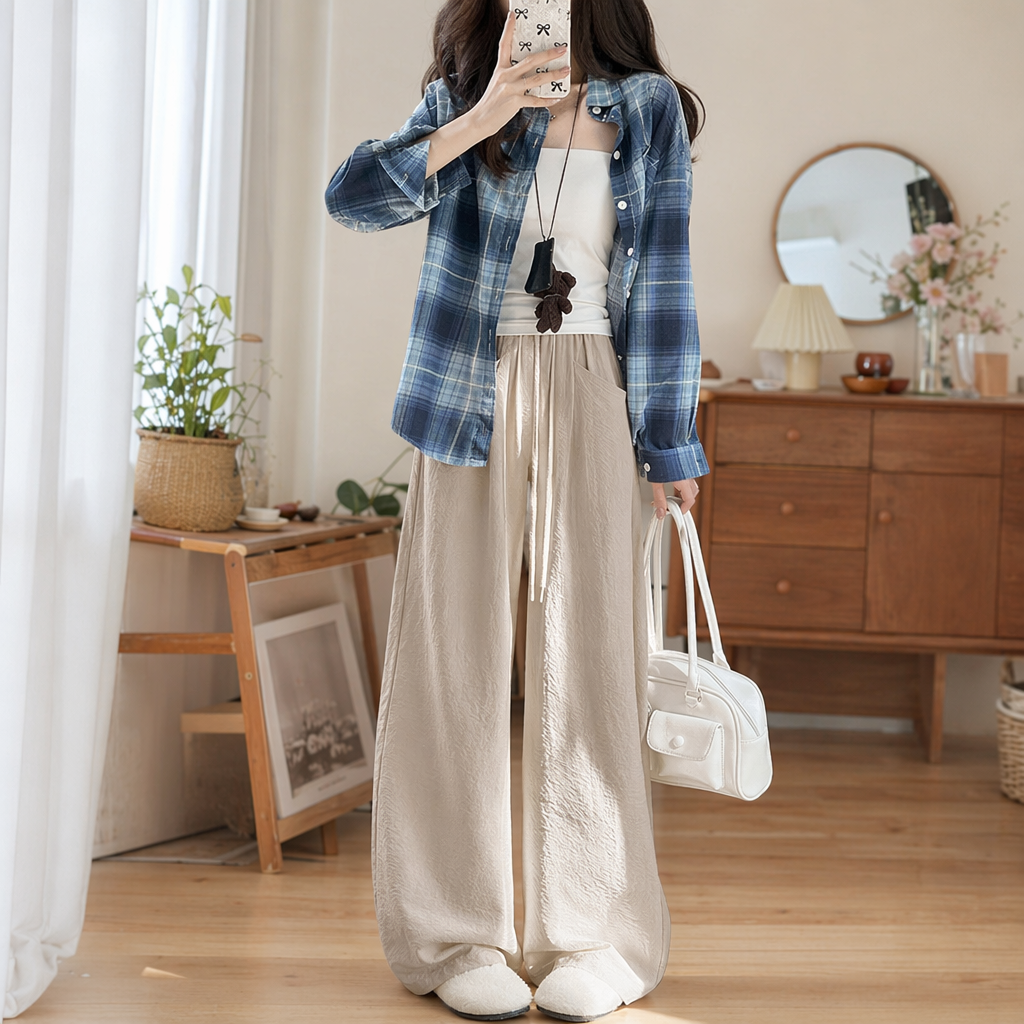 A fashionable look for women with a blue and white checkered shirt paired with beige wide-leg pants details Picture