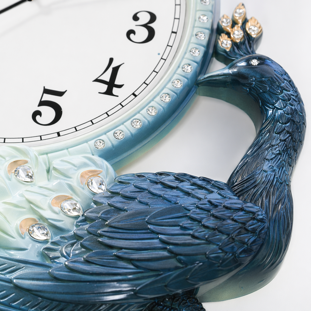 A peacock-shaped wall clock with a blue frame, white face and tail feathers decorated with crystal ornaments. It is a decorative clock for the living room and bedroom Application Scenario