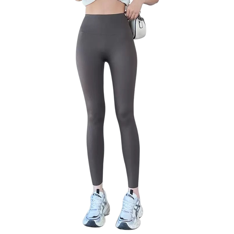 A close-up of the legs of grey high-waisted skinny pants paired with white sports shoes and a small bag Item Picture