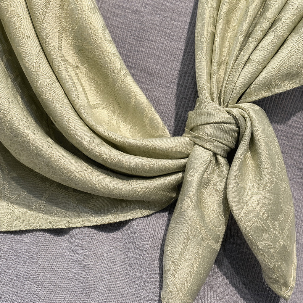 A light green printed silk scarf paired with a grey knitted sweater is a fashionable and versatile accessory for women Application Scenario