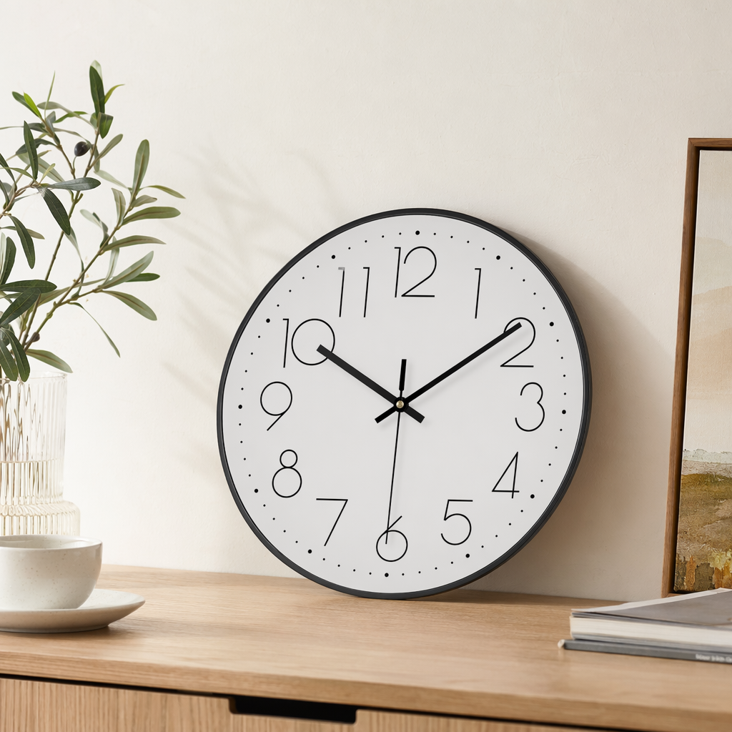 A simple wall clock with a black frame and a white dial, suitable for decoration in the living room and bedroom details Picture