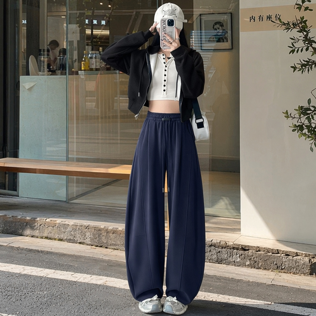A woman in navy blue wide-leg pants paired with a black hooded jacket and a white short top, the same style as the model details Picture