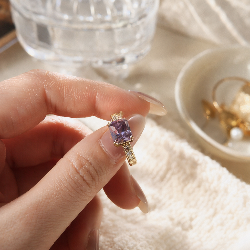 The center of the golden ring is set with a purple square zircon, and the sides of the ring arm are decorated with small crystals details Picture