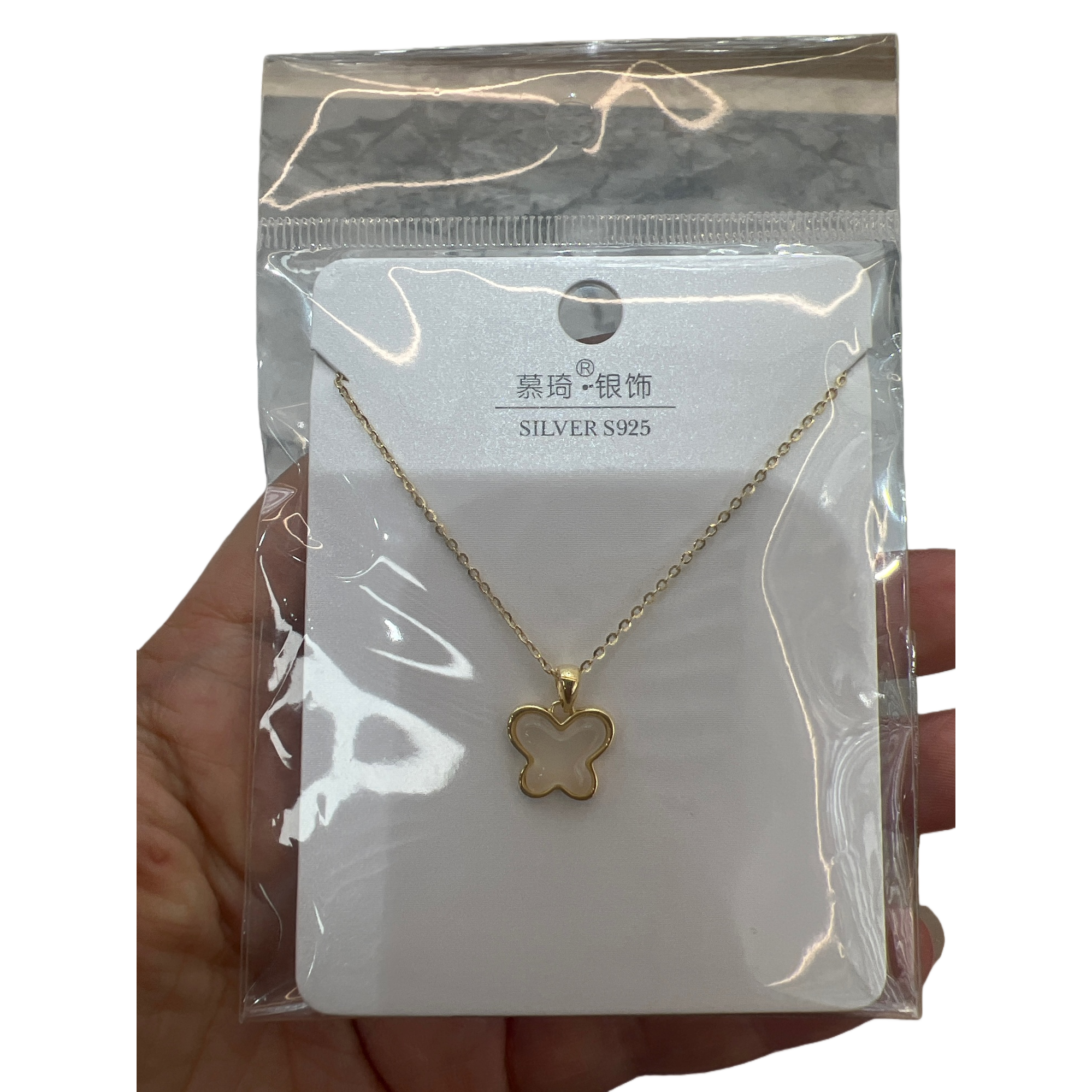 The golden butterfly pendant necklace is wrapped in a white card and sealed in a transparent plastic bag Item Picture
