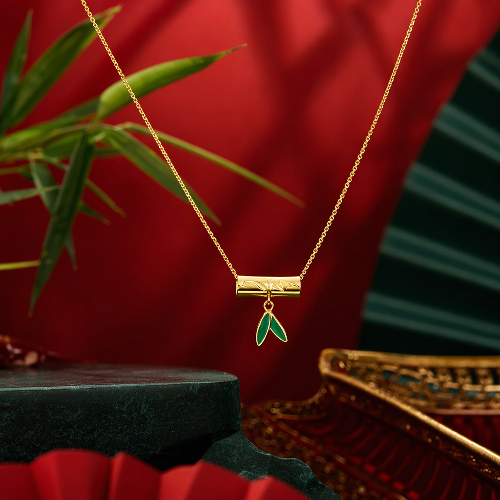 A golden bamboo pendant necklace with green leaves embellished on white cards, in a transparent bag for handheld display Specification image