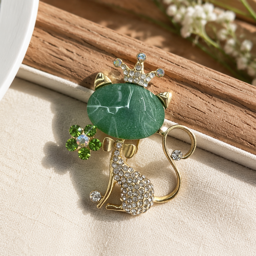 Green cat-shaped brooch, golden diamond-encrusted body, tail, crown with diamonds on the head, holding an emerald bouquet details Picture
