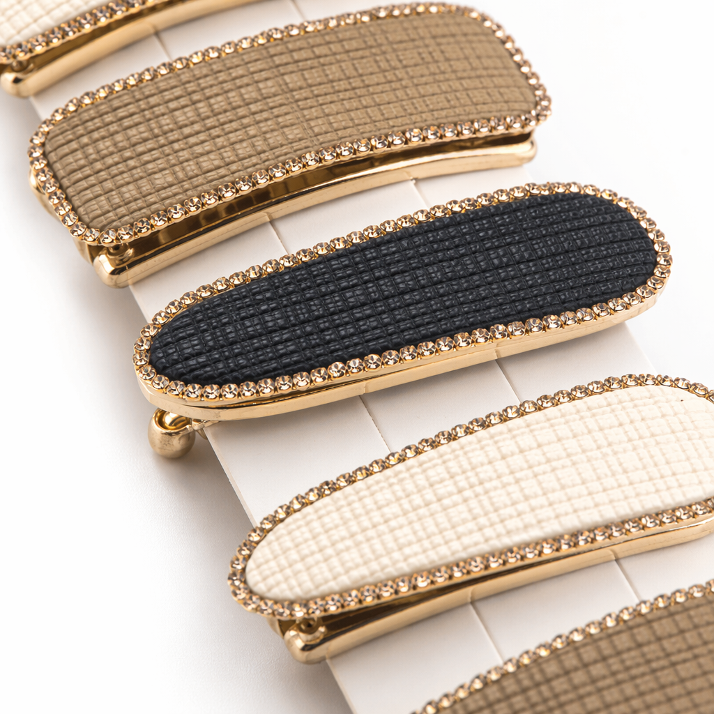 Five rectangular and oval-shaped hair clips with golden diamond-encrusted checkered patterns are handheld for display Application Scenario