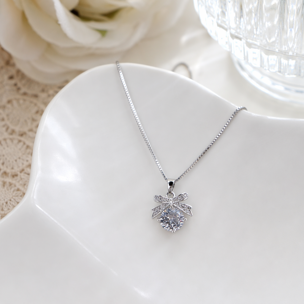 A silver alloy bow rhinestone pendant necklace hangs with round-cut crystals details Picture