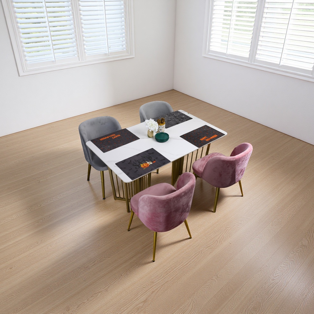 A white marble dining table with grey and pink suede chairs and Halloween-themed placemats details Picture