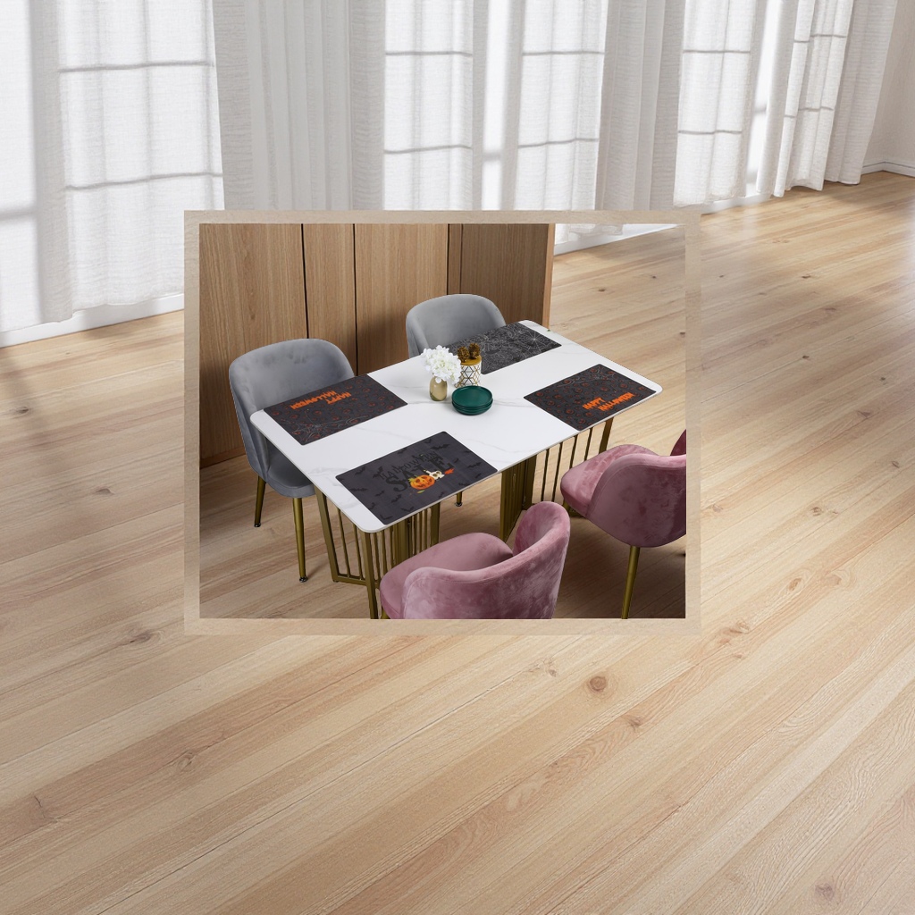 A white marble dining table with grey and pink suede chairs and Halloween-themed placemats