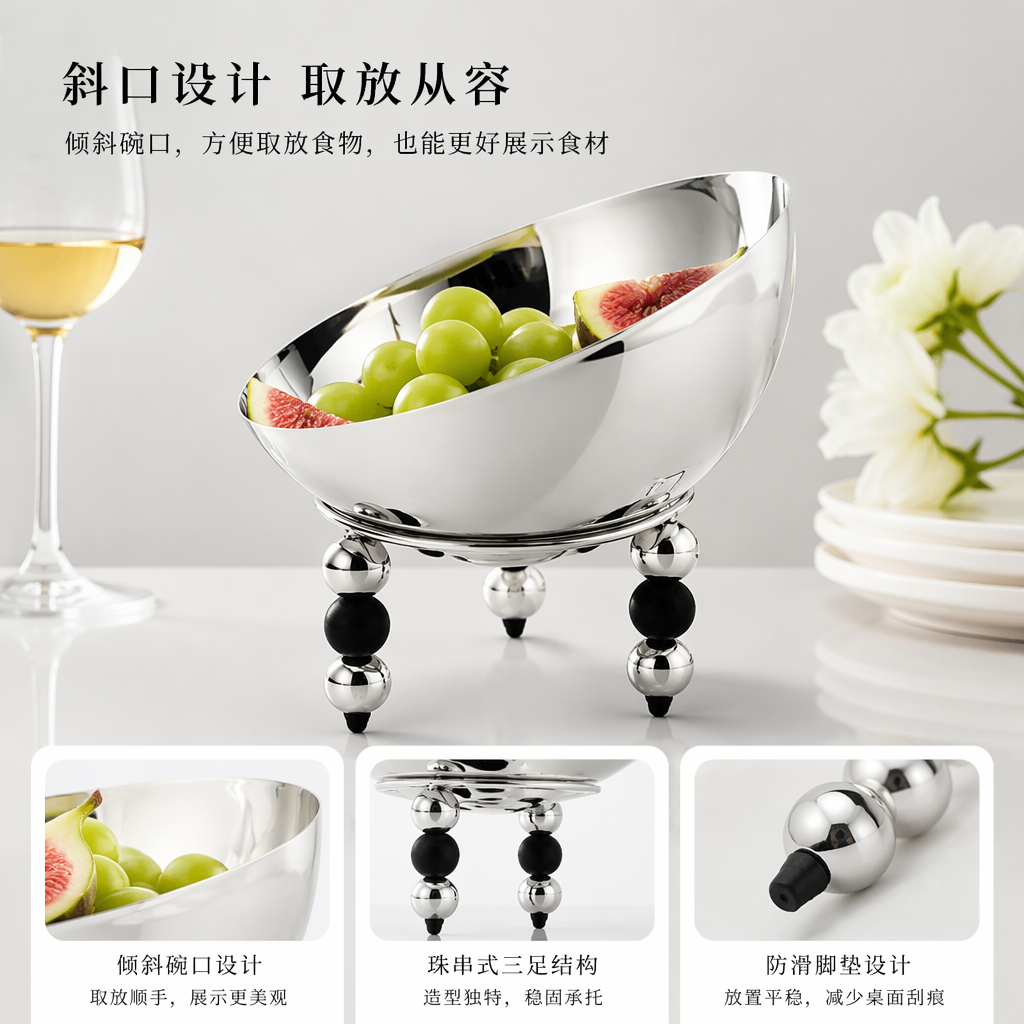 A silver metal bowl-shaped dining bowl with black and silver spherical feet