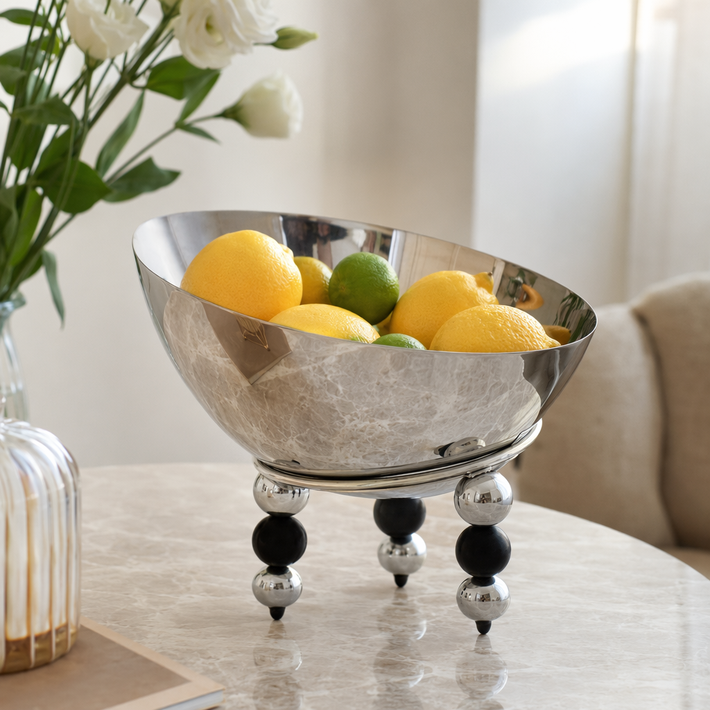 A silver metal bowl-shaped dining bowl with black and silver spherical feet details Picture
