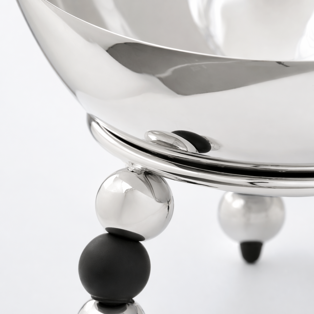 A silver metal bowl-shaped dining bowl with black and silver spherical feet Application Scenario