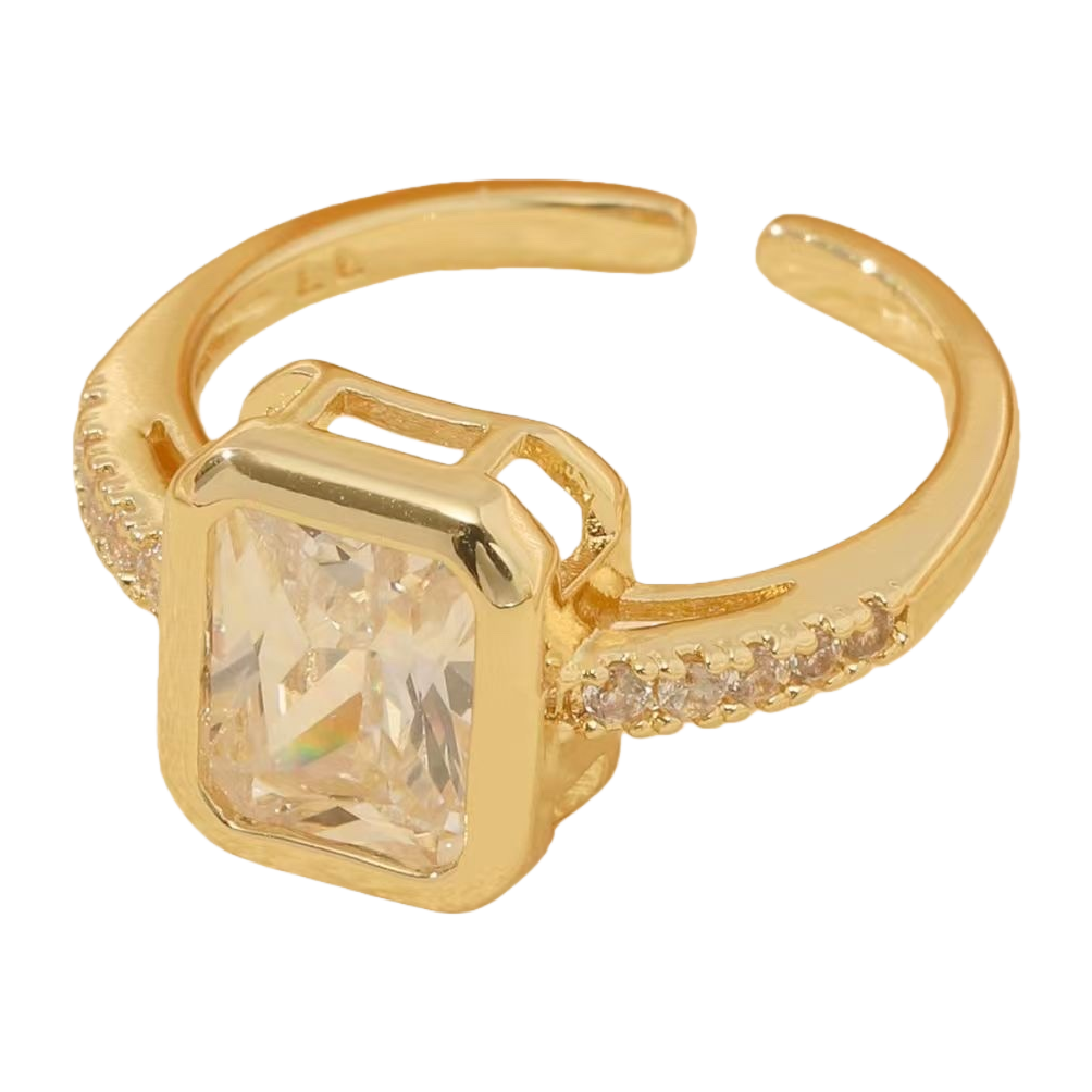 金色戒指，中央镶嵌方形透明宝石，戒臂两侧饰有小颗晶石白底实物图