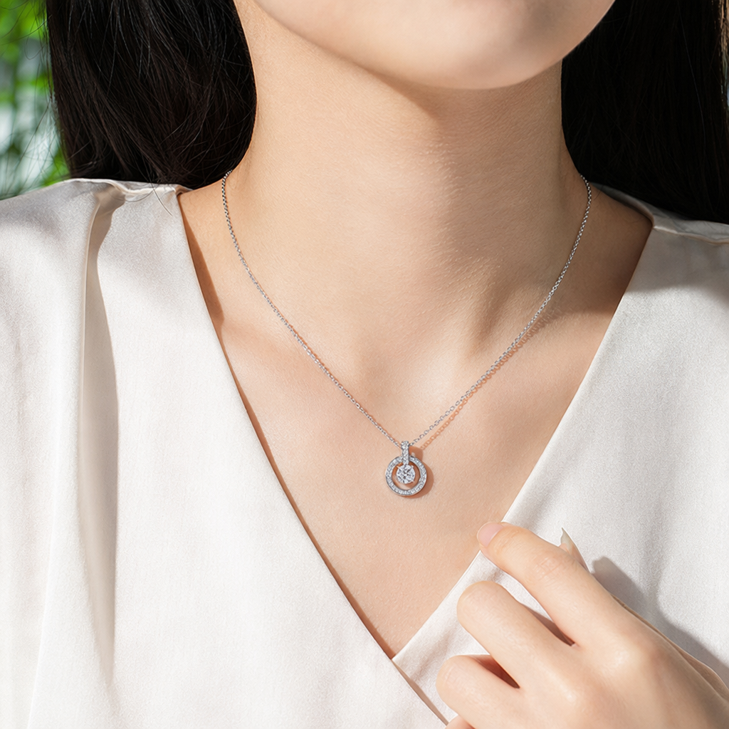 The silver necklace features a central circular main diamond and an outer ring closely set with small diamonds and a fine chain design details Picture