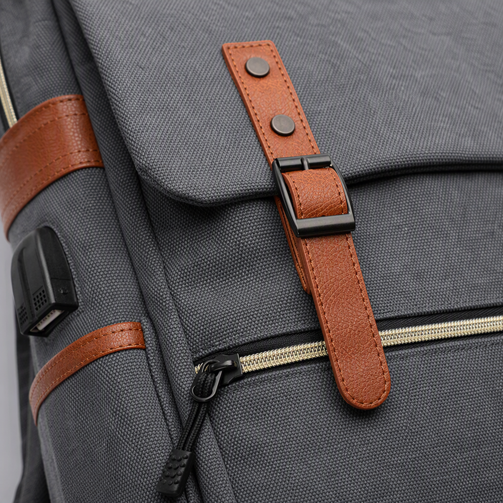 The grey backpack with brown leather trim and a USB charging port can charge smartphones Application Scenario