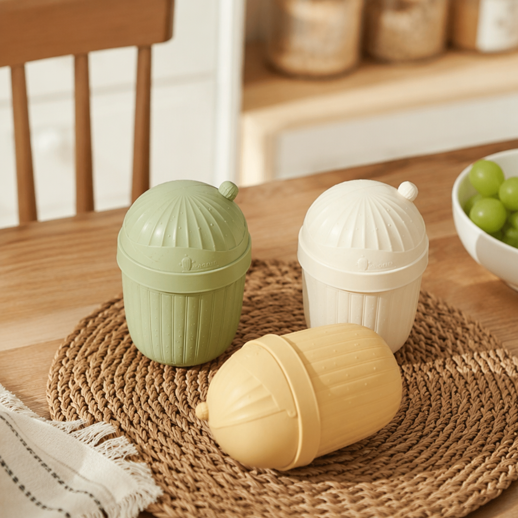 The creative three-color cactus flip lid trash can is green, off-white and light yellow. It is environmentally friendly and practical for home storage, placed on a checkered tablecloth details Picture