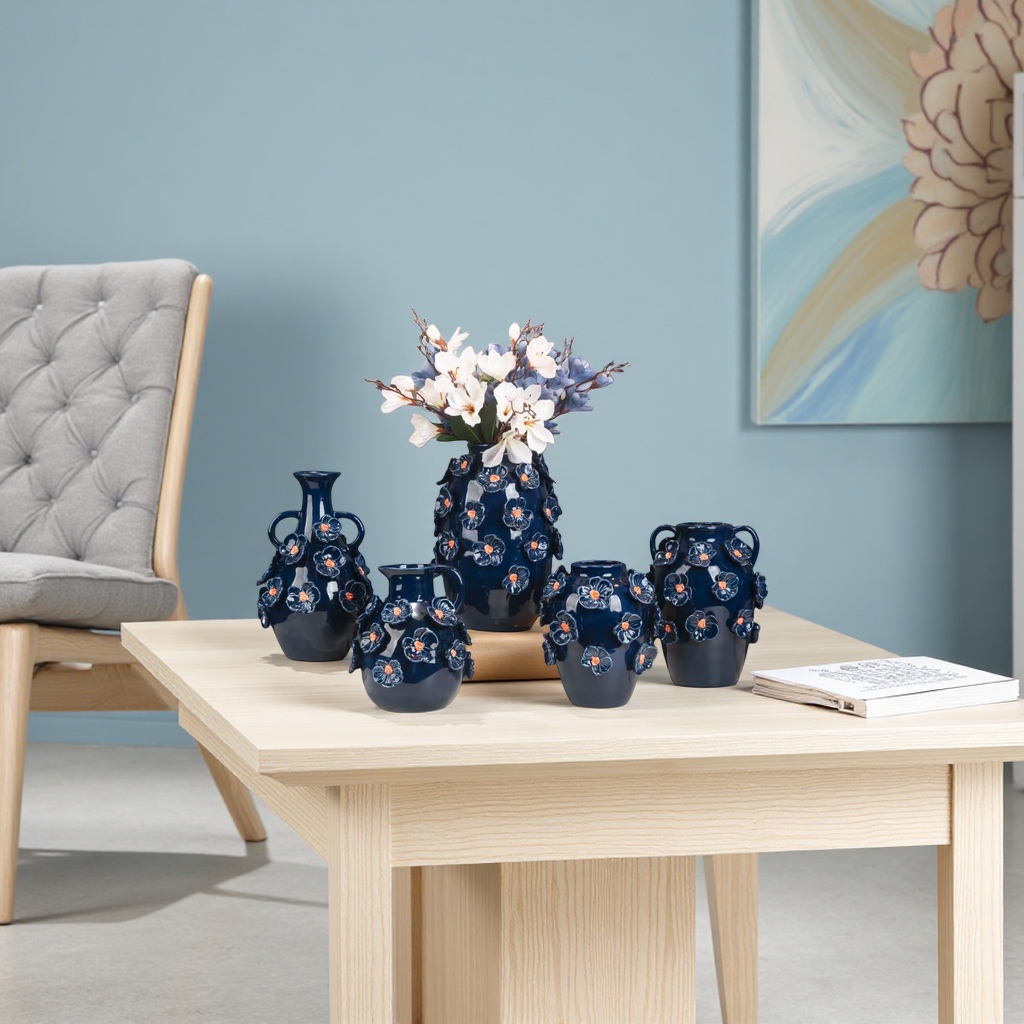 The deep blue ceramic vase set features a three-dimensional orange heart and white flower decoration. The central high vase is decorated with white and blue artificial flowers arranged in a staggered manner, with a background of Chinese ink-wash painting
