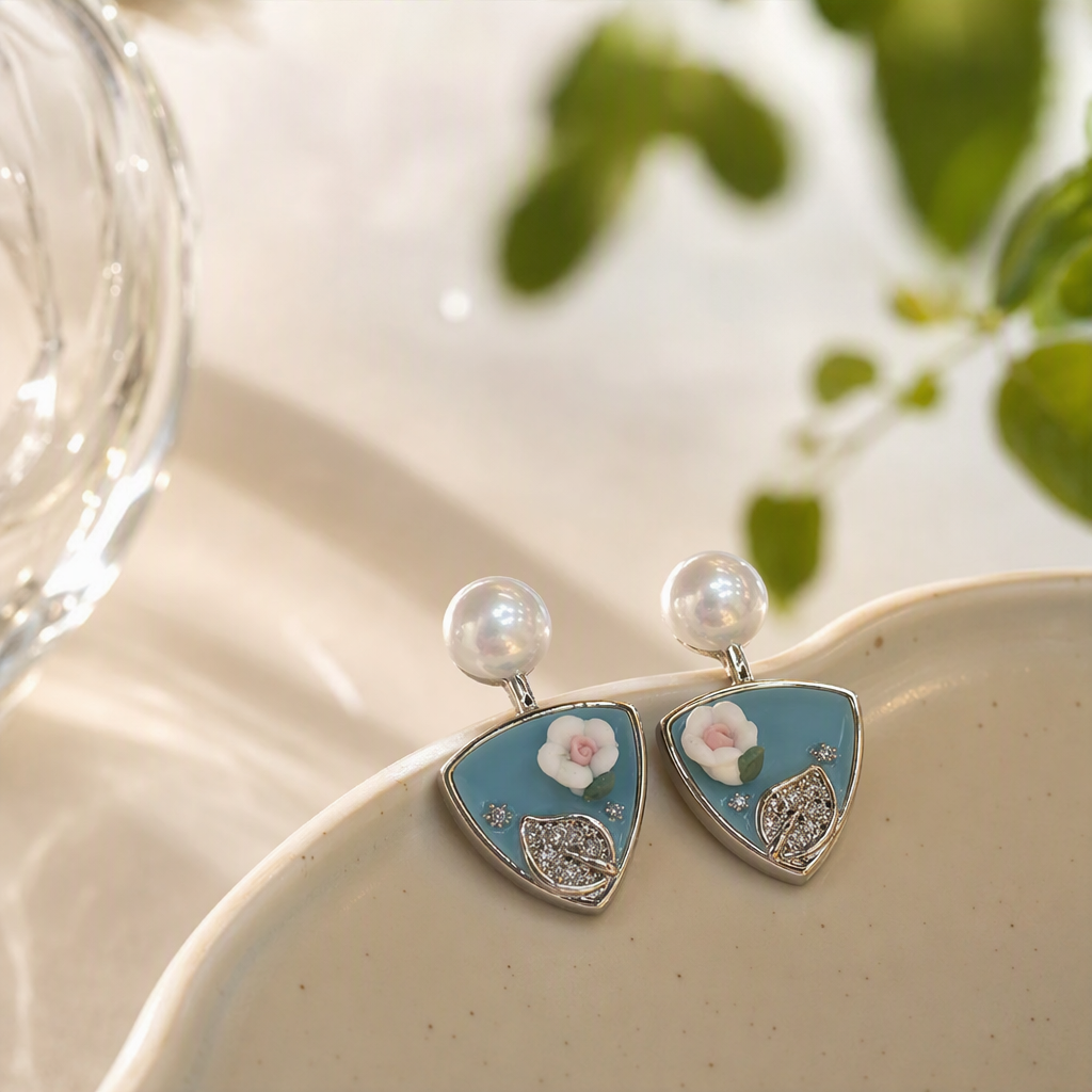 The blue background with white flower pearl stud earrings in the white jewelry box are simple, elegant and elegant earrings for women details Picture