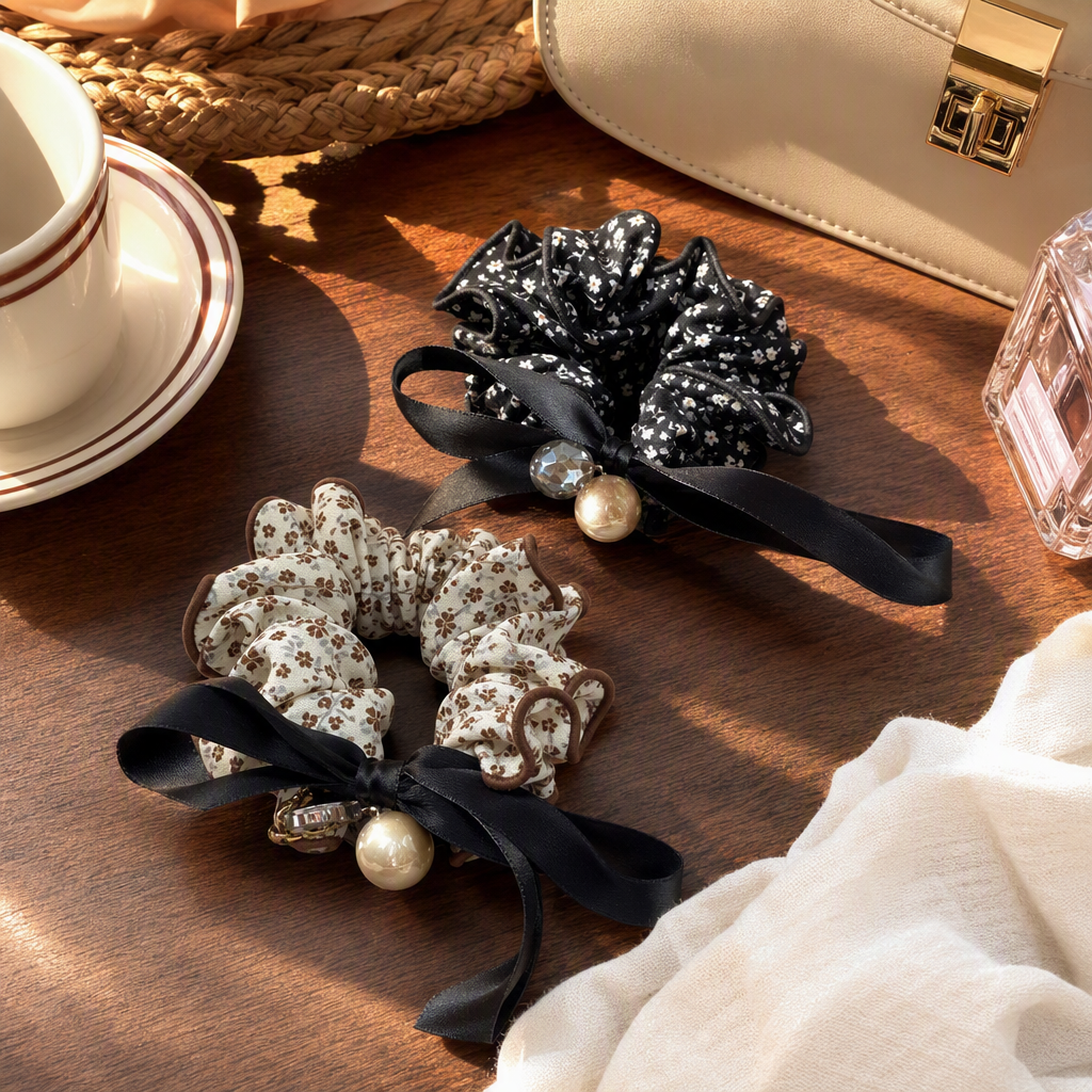 Black floral hair tie with pearl decoration, beige and brown floral hair tie, black ribbon, held on a wooden tray for display details Picture