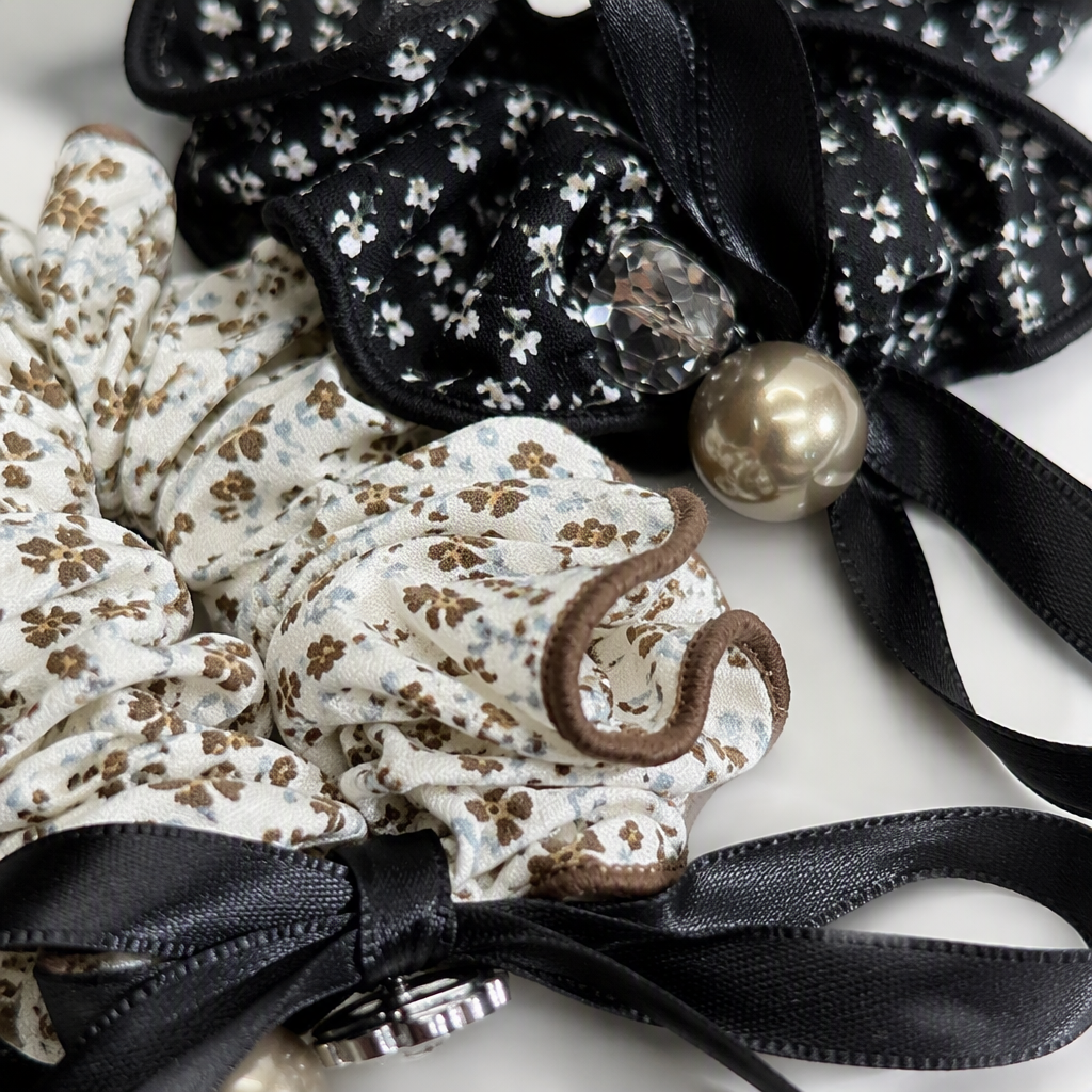 Black floral hair tie with pearl decoration, beige and brown floral hair tie, black ribbon, held on a wooden tray for display Application Scenario
