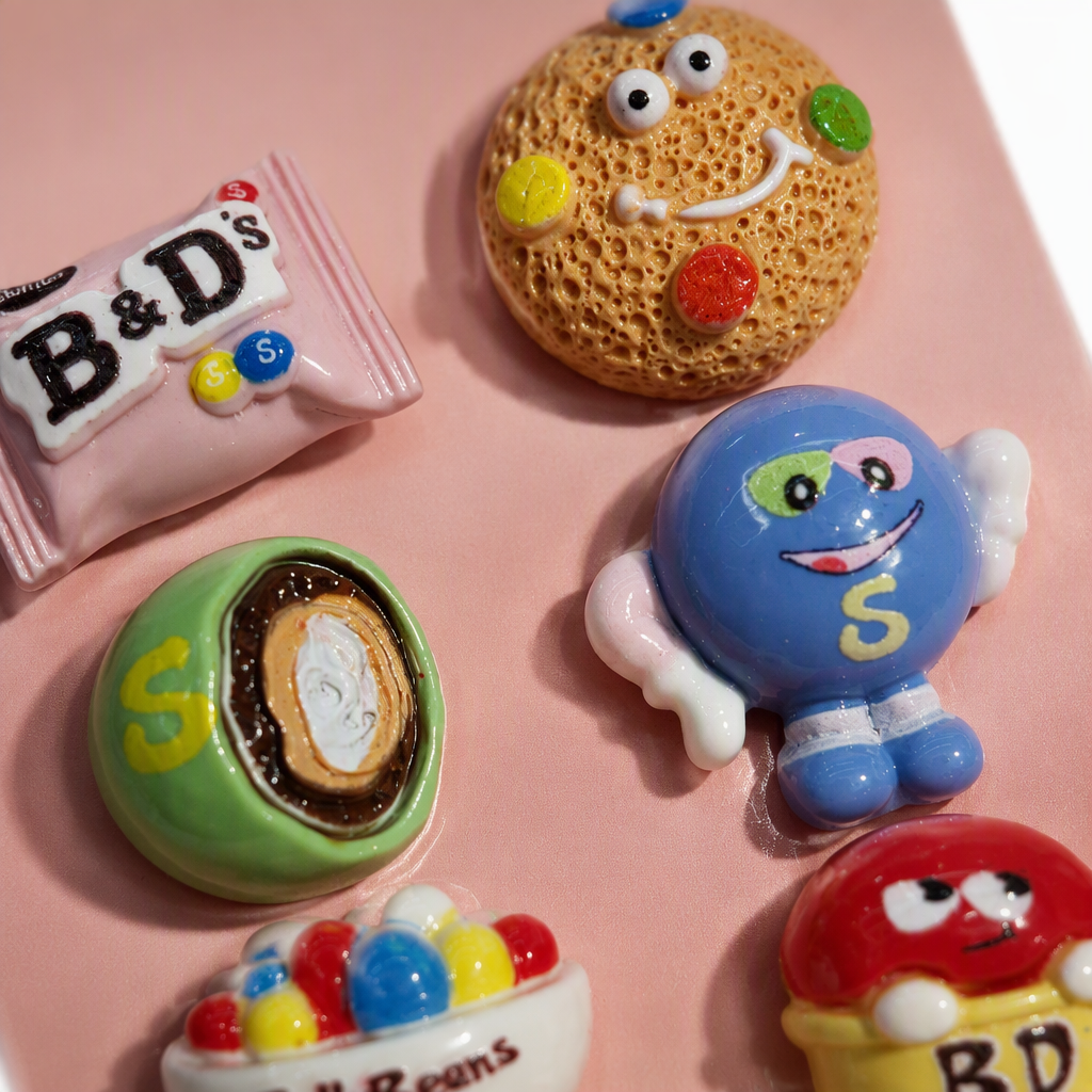 Six colorful candy-themed tiles with a pink background, B&D's chocolate cookie face, S-shaped egg roll, Smurfs, Jelly Beans, BD Skittles rainbow Application Scenario
