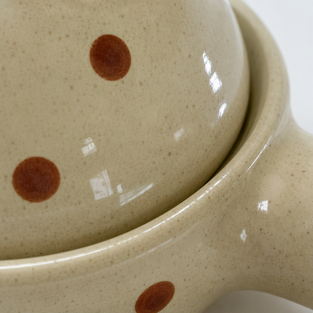 A mini kitchen cooking appliance with a handle and a lid made of ceramic with off-white spots Application Scenario