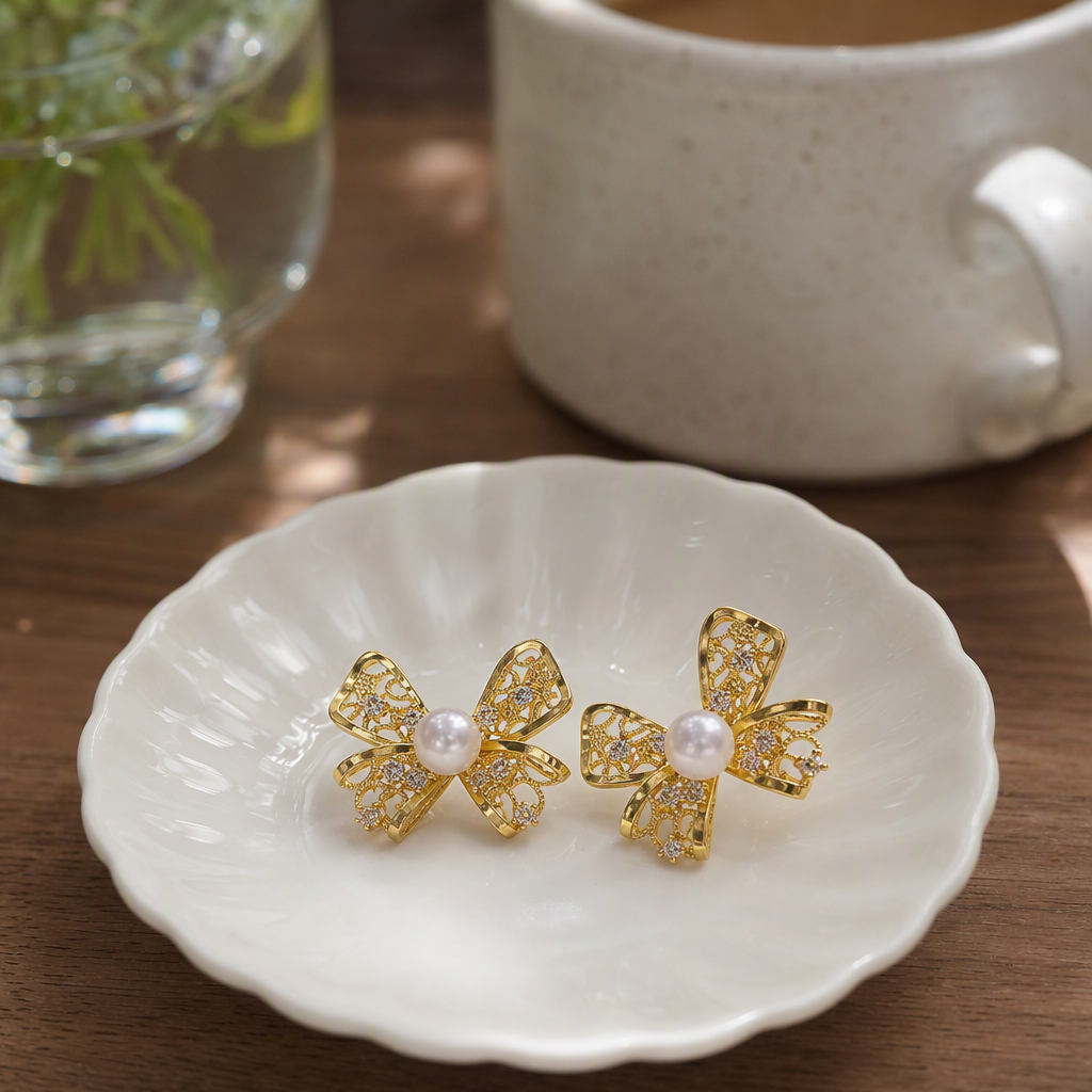 Golden bow stud earrings with pearls in the center and small diamonds as embellishments are fashionable earrings that are versatile and elegant for women details Picture