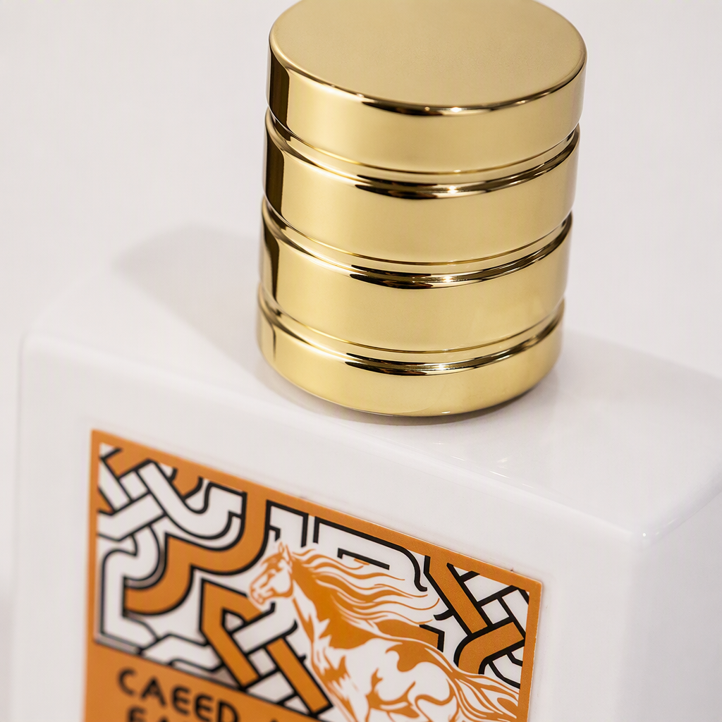 Golden screw cap, white square bottle body, orange-black geometric pattern label, silhouette of galloping horse, CAEEED AL FARSJAN brand packaging Application Scenario