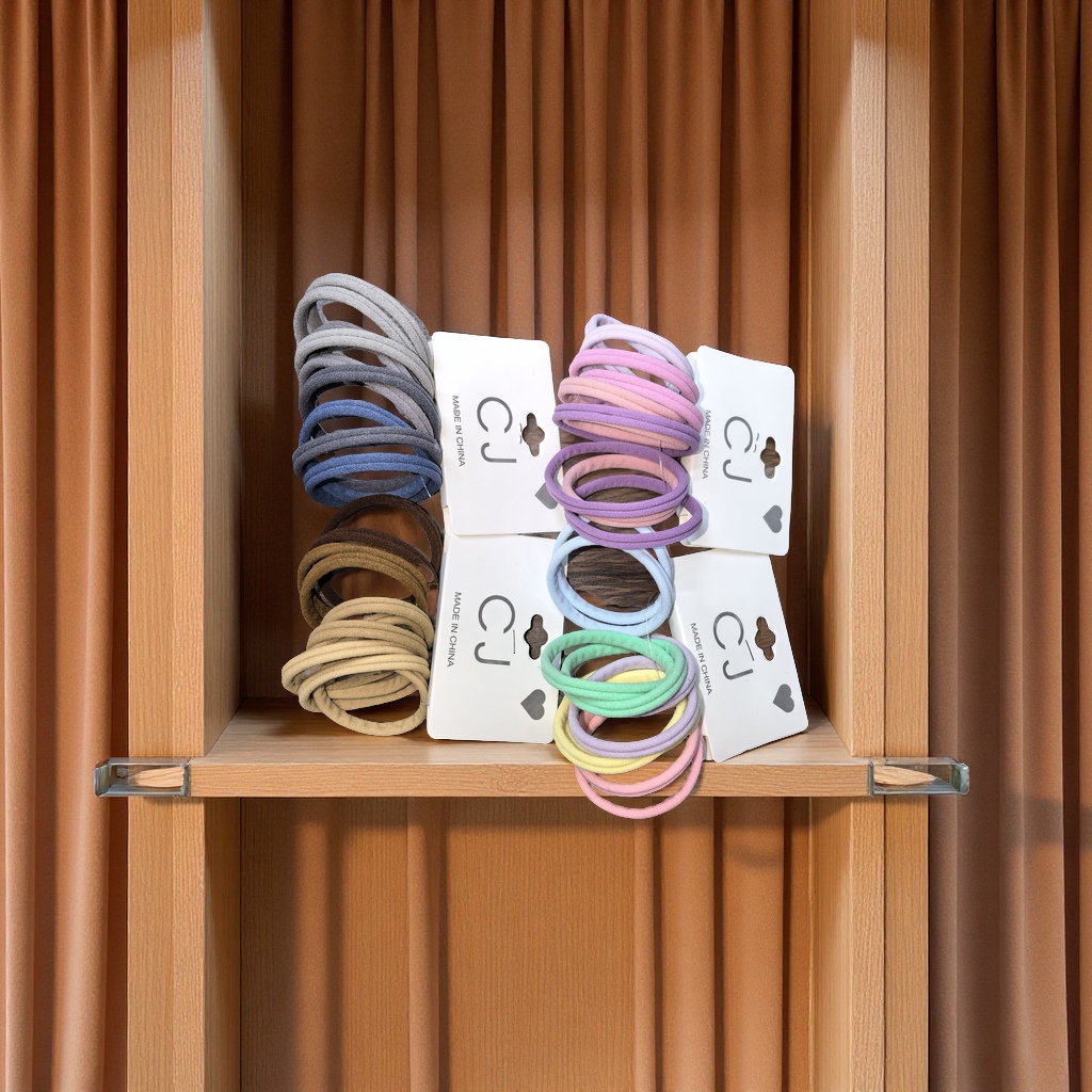 On the wooden display stand, hair ties are hung between the silk threads, and natural light gently spills in, presenting high-definition details and creating a simple yet refined fashion atmosphere.