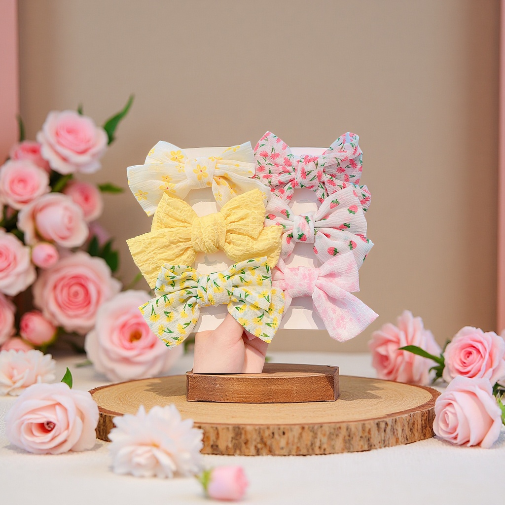 The children's bow hair clip is sweet and cute. It is a hair accessory on the back of the girl's head with a floral headpiece on the side