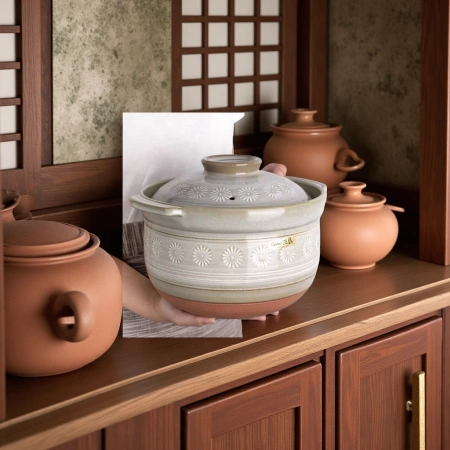 The Kangshu stew pot, with its double lid for cooking rice, is a clay pot and enamel kitchenware that is durable and keeps warm The Kangshu stew pot, with its double lid for cooking rice, is a clay pot and enamel kitchenware that is durable and keeps warm