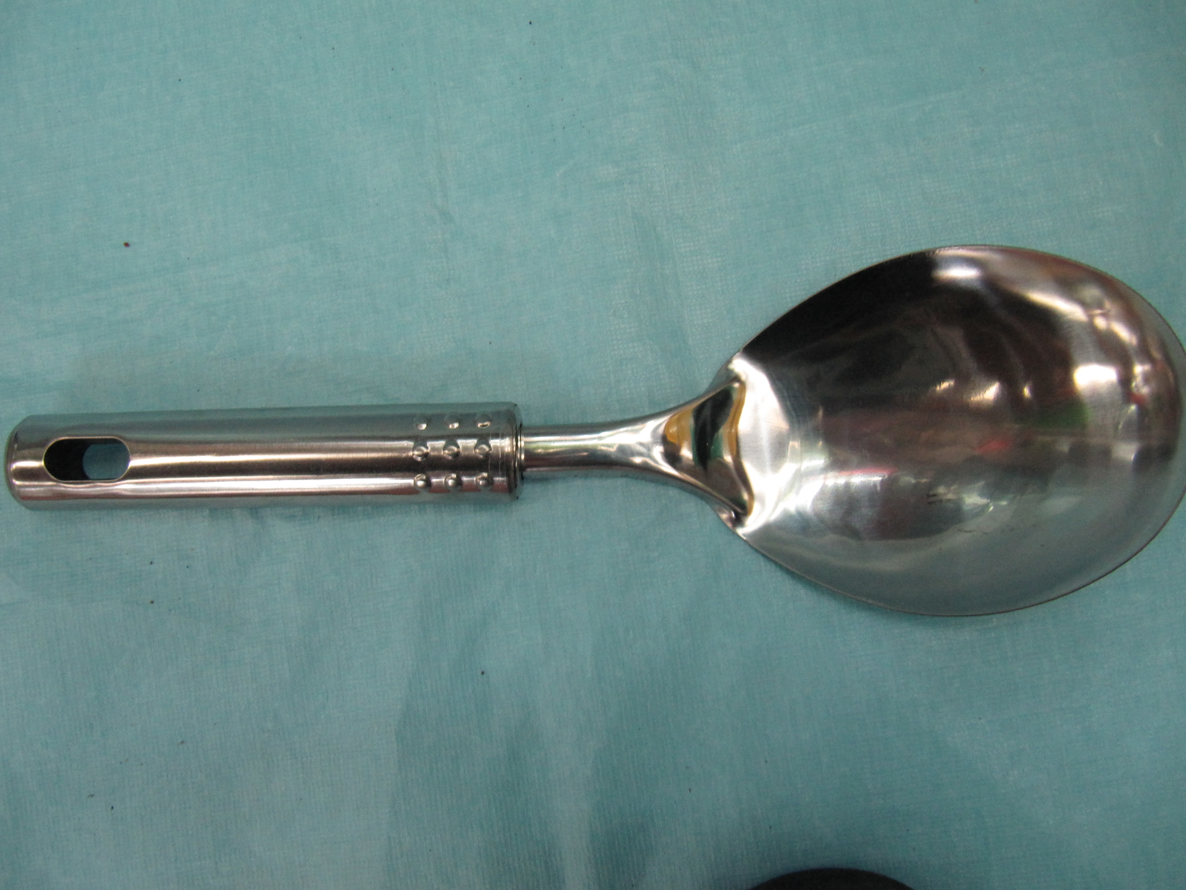 A short rice spoon with a steel handle and nine dots