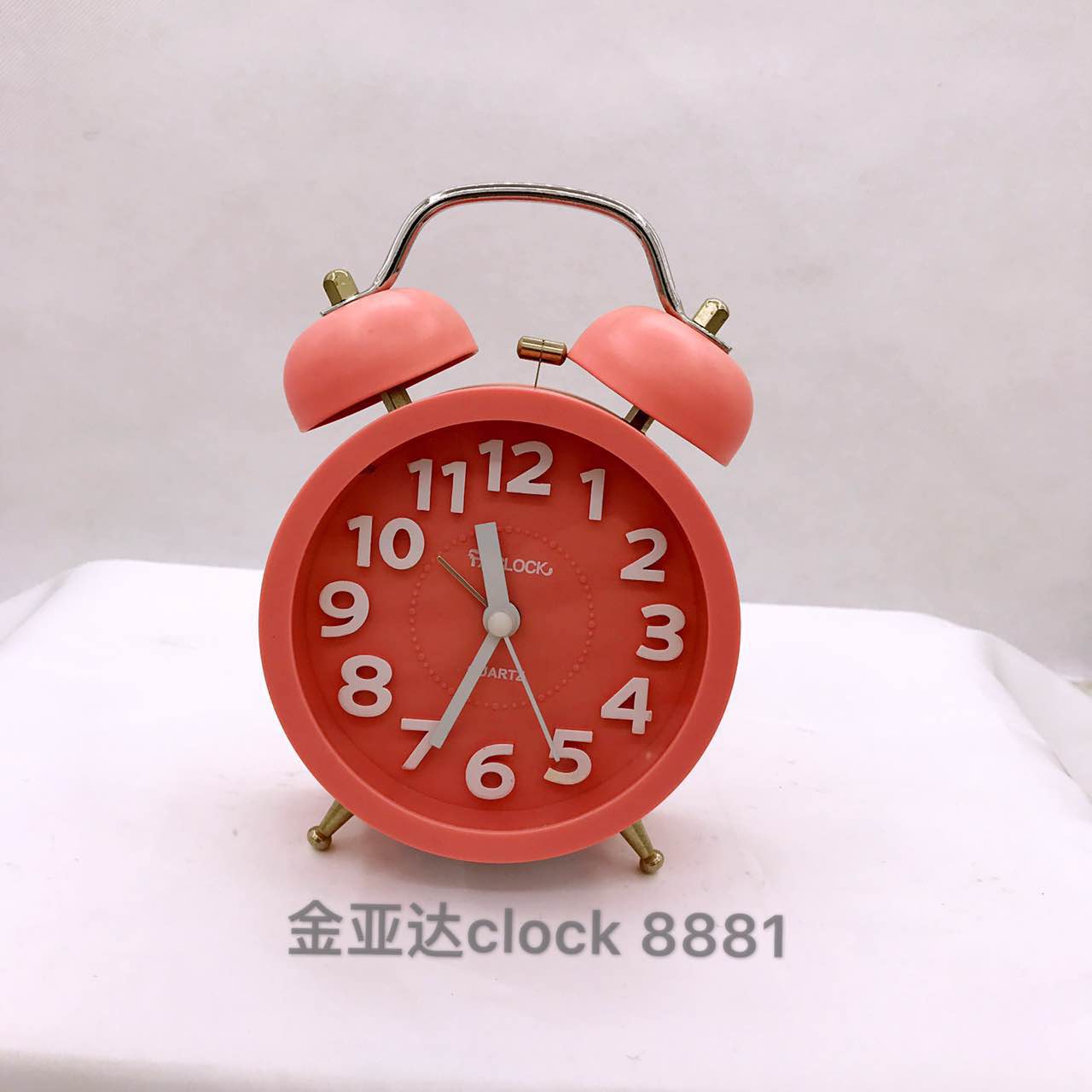 A small alarm clock with raised lettering