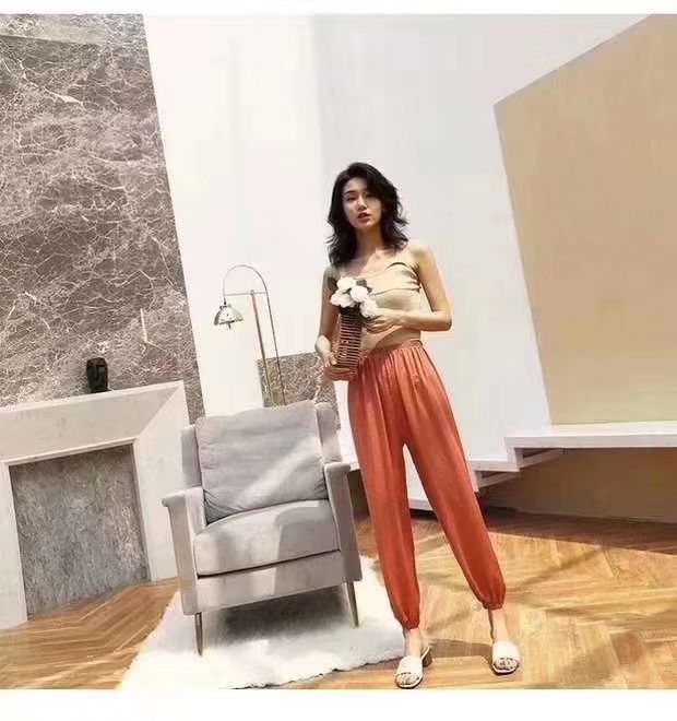 Woman wearing rose warm pants outdoors with coffee