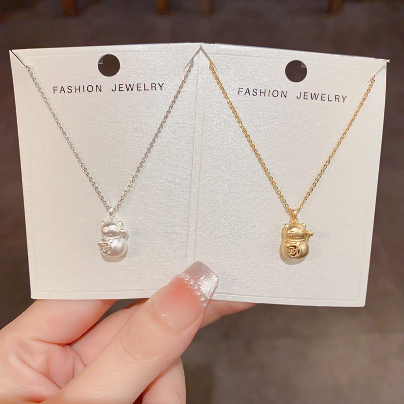 This niche, fashionable and simple design matte gold metal Maneki Neko pendant necklace exudes a light luxury and is a versatile necklace for daily use