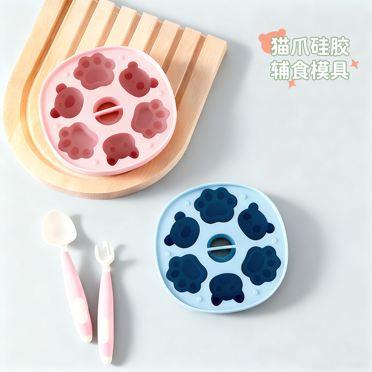 Pink and blue cat paw silicone baby food molds with pink spoons and forks