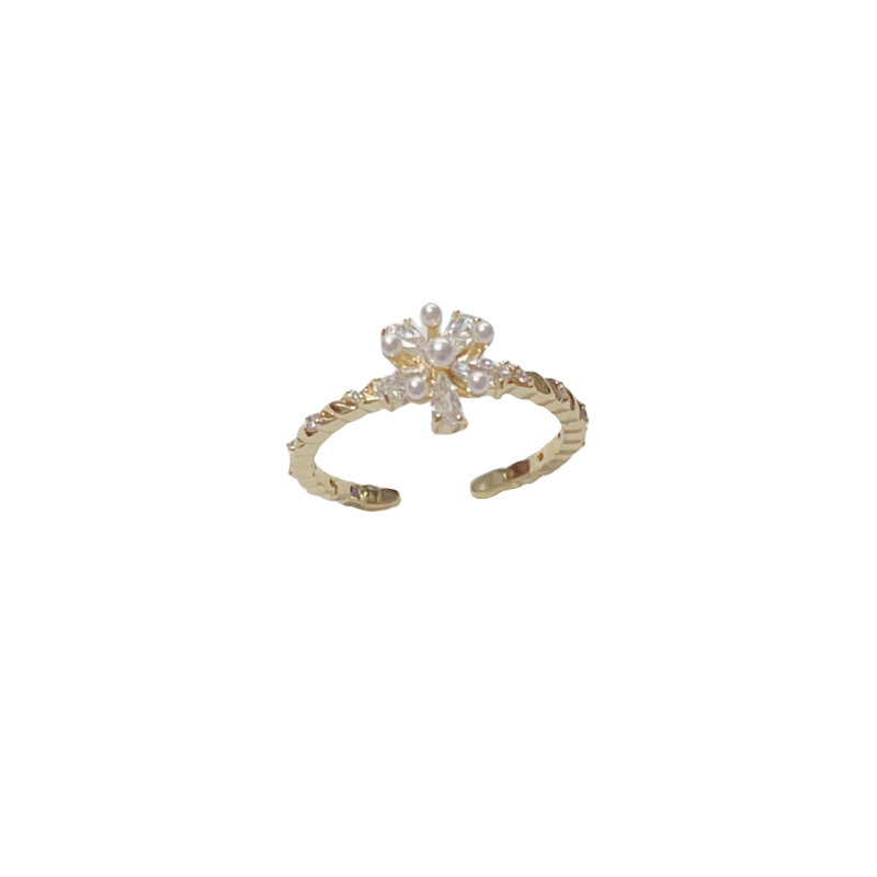 A Japanese and Korean niche diamond-encrusted pearl flower ring with an ins light luxury and high-end feel, simple and cold style. A woman who wears the ring with her mouth open Application Scenario