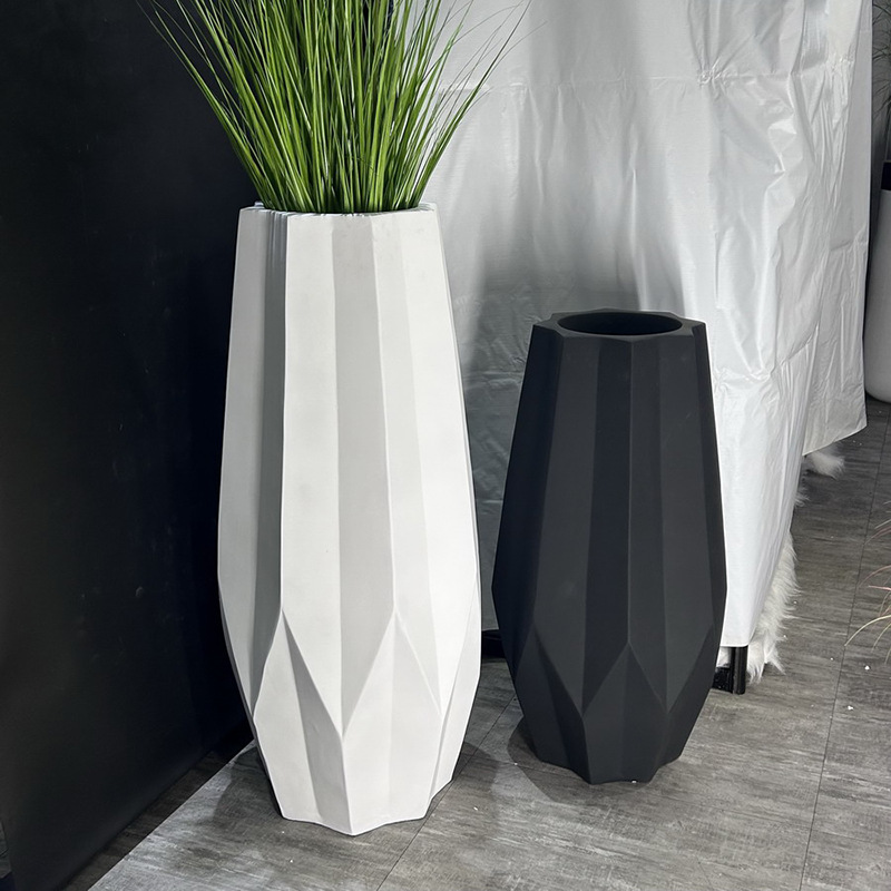 A large floor-standing plant arrangement in a minimalist style beside the sofa in the living room, featuring a new matte black and white bright color vase Application Scenario