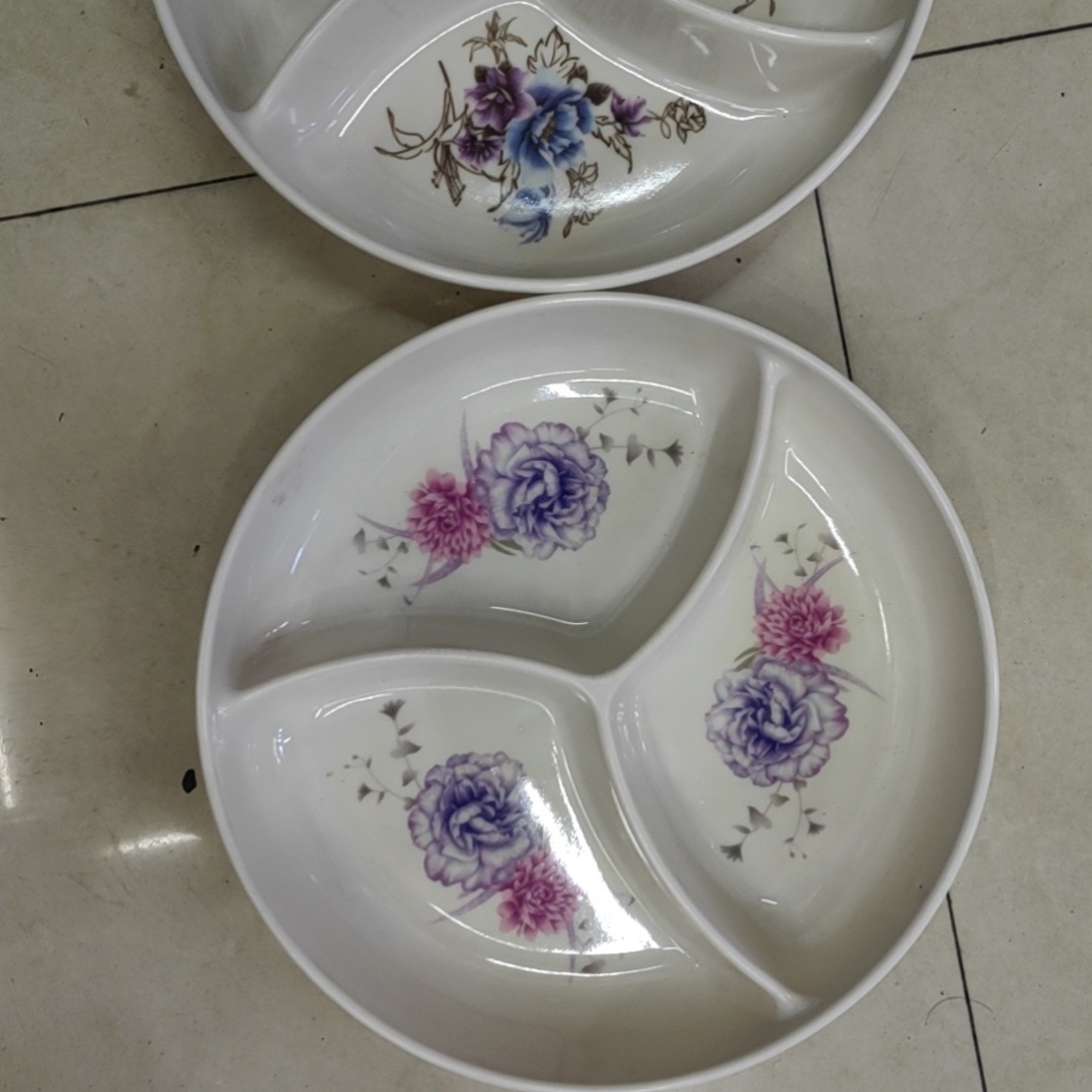 A melamine plate with three compartments for storing dried fruits and snacks at home full figure