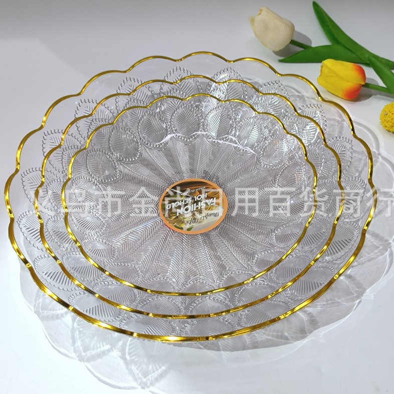 A high-end transparent solid color gold-edge fruit plate for home living room, a high-end plastic coffee table, and a candy plate placed on the front desk