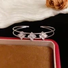 Wholesale of French light luxury, fashionable and retro diamond-encrusted four-leaf flower double-layer open bracelets with a unique and simple design sense details Picture