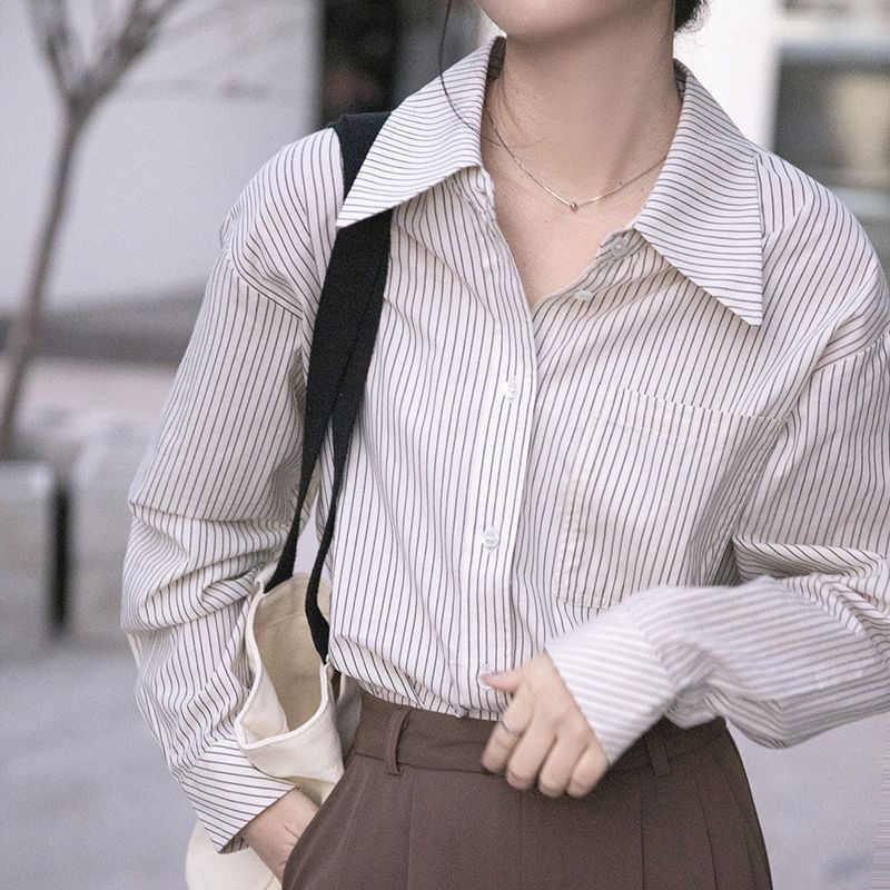 The new design of the blue striped shirt for women in Spring and autumn 2025 is unique, loose and slimming. It is a long-sleeved shirt worn outside in spring and autumn Application Scenario