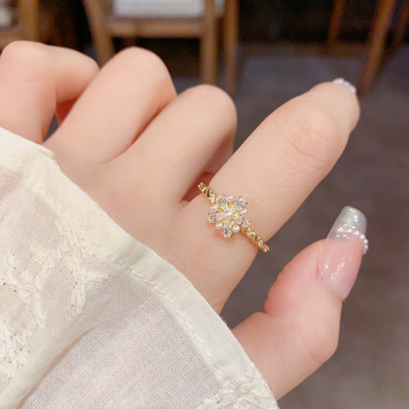 A Japanese and Korean niche diamond-encrusted pearl flower ring with an ins light luxury and high-end feel, simple and cold style. A woman who wears the ring with her mouth open Specification image