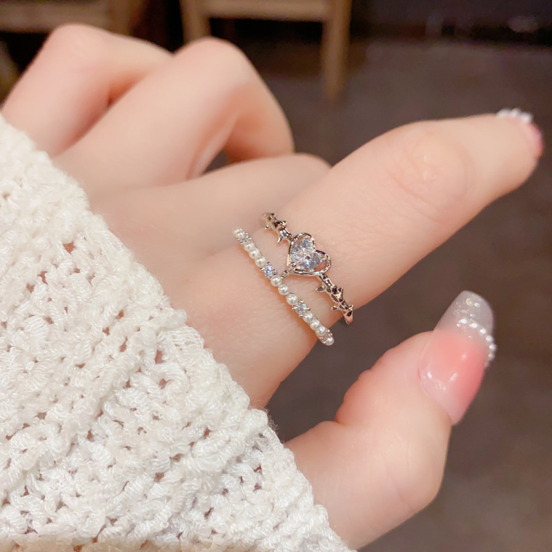 A light luxury and fashionable InS-style open-top ring for women, with a unique and simple design. It is a double-layered index finger ring made of zircon heart and pearl