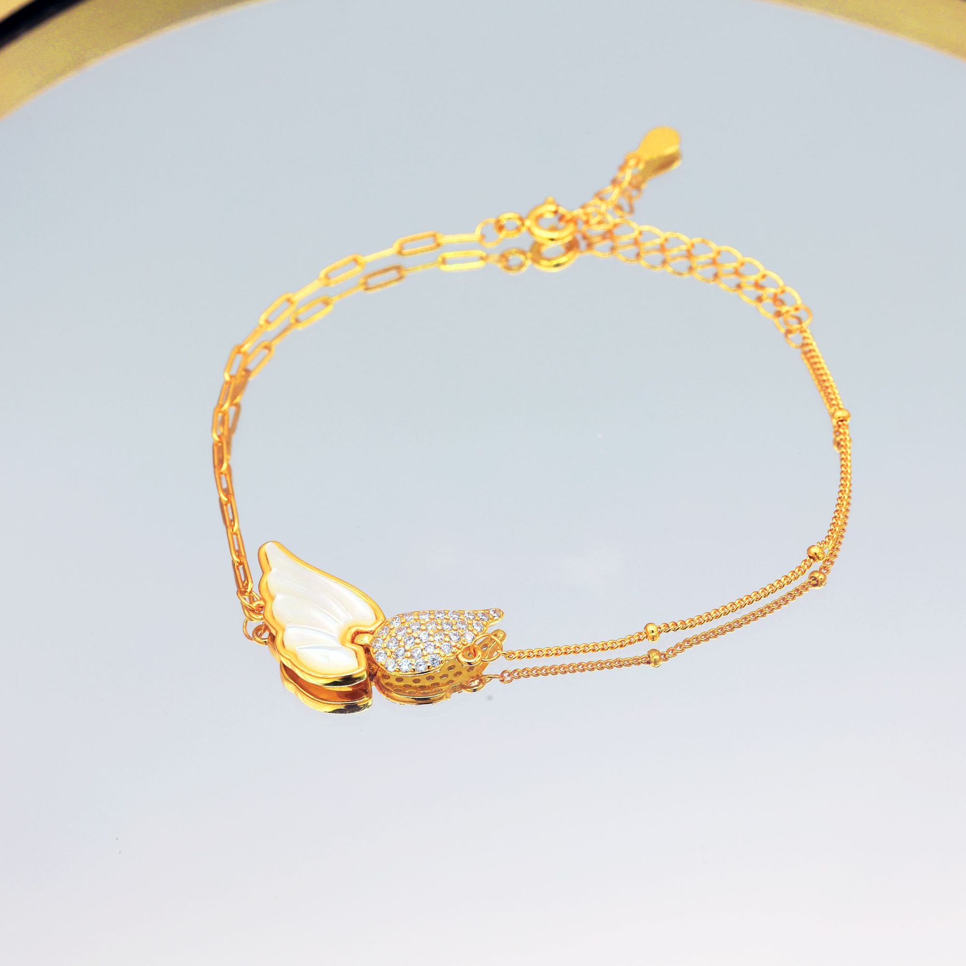 A simple and elegant wing-shaped bracelet gift featuring movable angel wings inlaid with white mother-of-pearl full figure